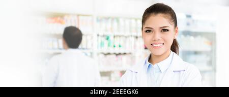 Lächelnde asiatische Apothekerin in Apotheke oder Apotheke - Panorama-Webbanner Stockfoto