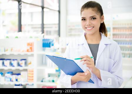 Lächelnde asiatische Apothekerin, die in einer Apotheke oder Apotheke arbeitet Stockfoto