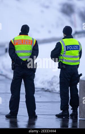 Breitenau, Deutschland. Februar 2021, 16th. Zwei Polizisten warten am Ausgang des Parkplatzes am Heidenholz auf der A17 bei Breitenau auf Pendler oder Reisende, die nach Deutschland einreisen und können einen negativen Corona-Test zeigen. In der Nacht vom 14. Februar 2021 traten die verschärften deutschen Einreisebestimmungen an der Grenze zur Tschechischen Republik zum Schutz vor gefährlichen Varianten des Coronavirus in Kraft. Quelle: Daniel Schäfer/dpa-Zentralbild/dpa/Alamy Live News Stockfoto