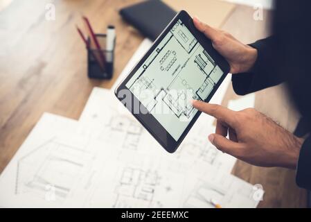 Immobilienmakler oder Architekt präsentiert Haus Grundriss zu Client auf Tablet-Computer-Bildschirm Stockfoto