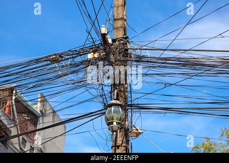 Kabelgewirr. Elektrische Säule mit zu vielen Anschlüssen. Asiatische Stromversorgung. Industrielle Elektrifizierungsmast mit Drahtgeflecht. Internet Stockfoto