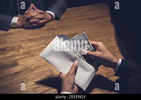 Geschäftsmann Zählen Geld, US-Dollar, in dem Umschlag nur von seinem Partner gegeben - Bestechung und Korruption Konzepte Stockfoto
