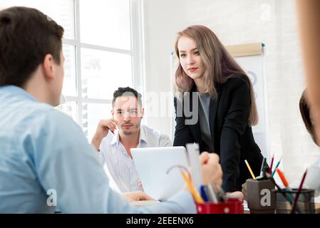 Weibliche Führerin steht und achtet auf ihre Kollegin in Die Besprechung Stockfoto