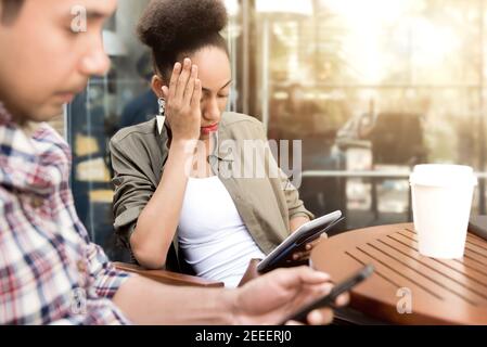 Menschen konzentrieren sich ernsthaft auf die Verwendung von Smartphone, während im Kaffee sitzen Shop - Social Media sucht Konzept Stockfoto