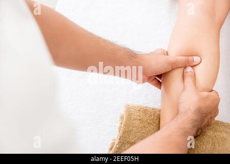 Hände des männlichen Therapeuten (Masseur), die einer Frau Massage geben Bein Stockfoto