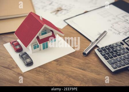 Hausmodell, Baupläne und Rechner auf Holztisch - Immobilien- und Immobilienkonzept Stockfoto