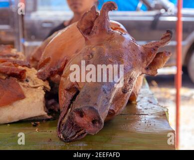 Gegrillter Schweinekopf, philippinische nationale Küche. Grill für ganze Schweine. Schweinebraten mit knuspriger Haut. Philippinische Festa-Küche. Gegrilltes Fleisch serviert auf Picknick. P Stockfoto