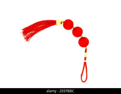 Chinesischer roter Knoten mit Quaste, Foto von oben. Symbol für asiatische Feiertage. Roter Seidenknoten isoliert. Chinesische Neujahrsdekoration. Orientalisches Dekor für Wohlstand Stockfoto