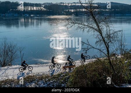 Winter im Ruhrgebiet, Baldeneysee, schneebedeckter, teilweise gefrorener See, Spaziergänger am Uferweg, Westufer, Essen, NRW, Deutschland, Stockfoto