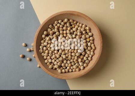 Holzschale mit frischen Kichererbsen auf zweifarbigem Hintergrund Stockfoto