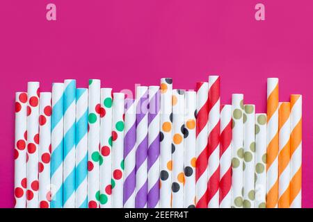 Gestreifte und gepunktete Trinkhalme aus Papier auf rosa Hintergrund Draufsicht. Umweltfreundliches Konzept Stockfoto