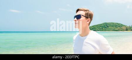 Junger Tourist mit Sonnenbrille am Strand Sommer - Panorama-Banner Stockfoto