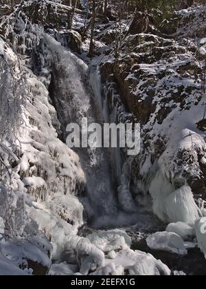 Bizarre Winterlandschaft mit Wasserfall Todtnauer Wasserfälle zwischen gefrorenen Felsen mit Eiszapfen und schneebedeckten Bäumen an sonnigen Tagen bei Todtnau. Stockfoto