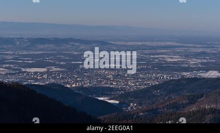 Schöne Luftaufnahme der Stadt Freiburg im Breisgau, Kaiserstuhl und Vogesen am Horizont im Winter mit schneebedeckter Landschaft. Stockfoto