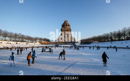 Leipzig, Deutschland. Februar 2021, 13th. Leipzigers Schlittschuh über das Eis auf dem See der tausend Tränen vor dem Denkmal zur Schlacht der Nationen. Nach frostfreien Tagen laden zumindest die flachen Teiche zum Eislaufen ein. Quelle: Jan Woitas/dpa-Zentralbild/ZB/dpa/Alamy Live News Stockfoto