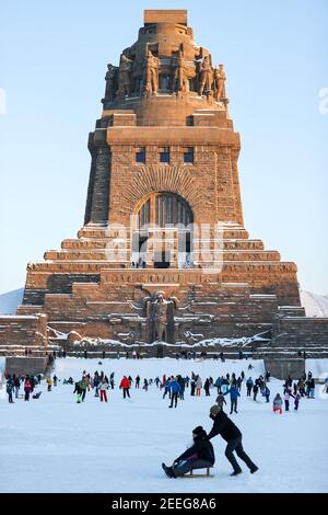 Leipzig, Deutschland. Februar 2021, 13th. Leipzigers Schlittschuh über das Eis auf dem See der tausend Tränen vor dem Denkmal zur Schlacht der Nationen. Nach frostfreien Tagen laden zumindest die flachen Teiche zum Eislaufen ein. Quelle: Jan Woitas/dpa-Zentralbild/ZB/dpa/Alamy Live News Stockfoto