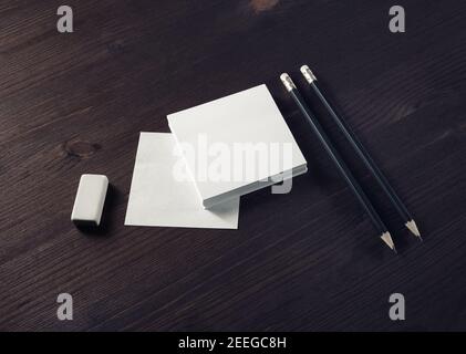 Leere Notizen, Bleistifte und Radiergummi auf Holztisch Hintergrund. Schreibwarenmockup. Objekte zum Platzieren Ihres Designs. Stockfoto