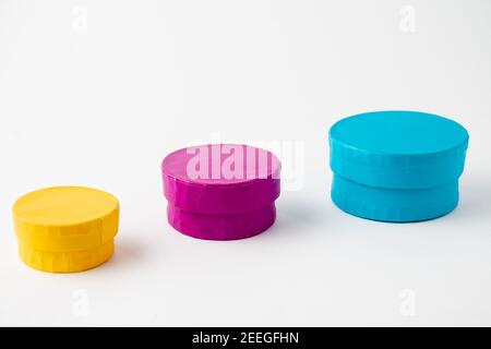 Ansicht von drei runden Boxen in blau, gelb und lila Farbe, auf weißem Hintergrund, horizontal Stockfoto