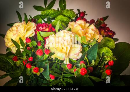 Blumenstrauß, grün rot gelb weiß und rosa Farben mit großen grünen Blättern Stockfoto
