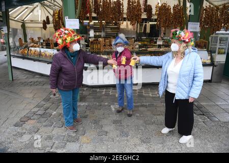 München, Deutschland. Februar 2021, 16th. Die Marktfrauen Erika Schuster (l-r), Annemarie Doll und Cristl lang stehen am Karnevalsdienstag am Viktualienmarkt. Der traditionelle Tanz der Marktfrauen wird dieses Jahr wegen der Corona-Pandemie nicht stattfinden. Quelle: Felix Hörhager/dpa/Alamy Live News Stockfoto