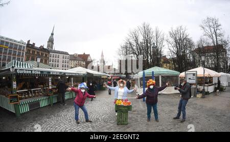 München, Deutschland. Februar 2021, 16th. Marktfrauen Annemarie Doll (l-r), Christl lang und Erika Schuster stehen am Faschingsdienstag mit Obstkisten und Blumen auf dem Viktualienmarkt. Der traditionelle Tanz der Marktfrauen wird dieses Jahr wegen der Corona-Pandemie nicht stattfinden. Quelle: Felix Hörhager/dpa/Alamy Live News Stockfoto