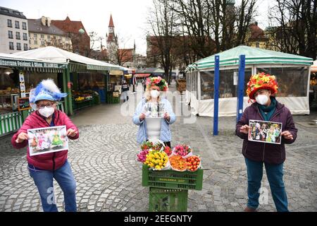 München, Deutschland. Februar 2021, 16th. Marktfrauen Annemarie Doll (l-r), Christl lang und Erika Schuster stehen am Faschingsdienstag mit Obstkisten und Blumen auf dem Viktualienmarkt. Der traditionelle Tanz der Marktfrauen wird dieses Jahr wegen der Corona-Pandemie nicht stattfinden. Quelle: Felix Hörhager/dpa/Alamy Live News Stockfoto