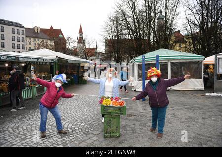 München, Deutschland. Februar 2021, 16th. Marktfrauen Annemarie Doll (l-r), Christl lang und Erika Schuster stehen am Faschingsdienstag mit Obstkisten und Blumen auf dem Viktualienmarkt. Der traditionelle Tanz der Marktfrauen wird dieses Jahr wegen der Corona-Pandemie nicht stattfinden. Quelle: Felix Hörhager/dpa/Alamy Live News Stockfoto