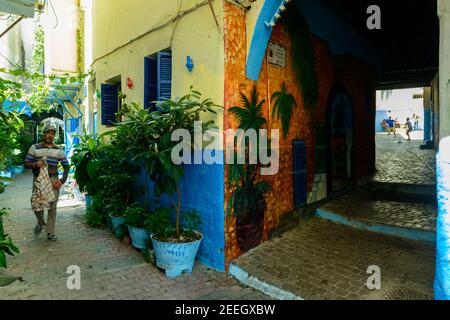 Eine der engen Gassen mit entzückenden Gemälden an den Wänden in der Medina von Tanger, Marokko. Stockfoto