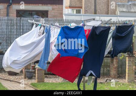 Wasch hängen Sie an einer rotierenden Wäscheleine, die in den Wind in einem Garten weht, Northampton, England, Großbritannien. Stockfoto