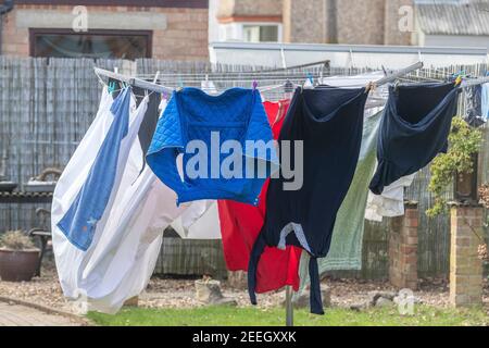 Wasch hängen Sie an einer rotierenden Wäscheleine, die in den Wind in einem Garten weht, Northampton, England, Großbritannien. Stockfoto