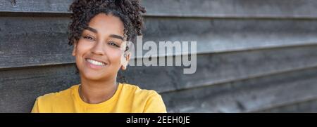 Panorama Mädchen Teenager Teenager weiblich junge afroamerikanische Mischrasse Biracial Frau außerhalb lächelnd mit perfekten Zähnen Panorama Header Web Banner Stockfoto