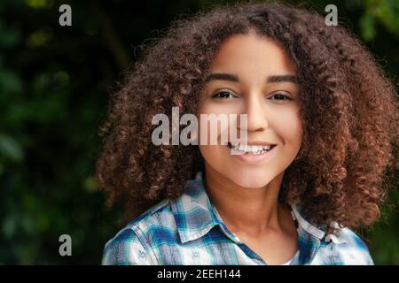 Outdoor-Porträt von schönen glücklich schwarz gemischt Rasse biracial African American girl Teenager weibliches Kind lächelnd mit perfekten Zähnen Stockfoto