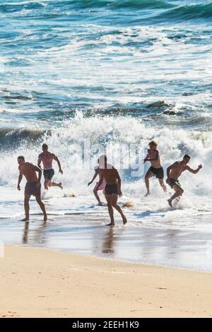 Männliche Urlauber auf einem Aufenthalt Urlaub Spaß am Meer am Fistral Beach in Newquay in Cornwall. Stockfoto