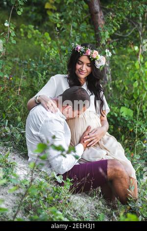 Junge schwangere Frau mit ihrem Mann genießen die Natur in lässigen und Stil Jeans und weißen T-Shirt. Stockfoto