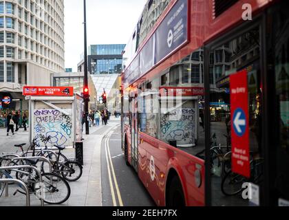 Straßenszene im Stadtzentrum mit dem legendären London Route Master Roter Bus wartet auf Passagiere auf der geschäftigen Regent Street mit Vandalismus Graffiti auf Gebäuden Stockfoto