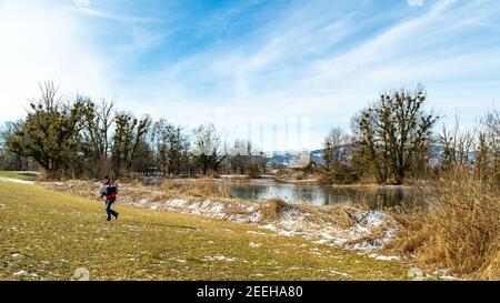 Fotograf am Ufer, Schleichen Löcher in der Morgenlicht in der Winterkälte. Ufer des Bodensees mit Schilf, Büschen und Bäumen. Schleienlöcher, Hart Stockfoto