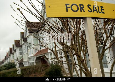 Immobilienmakler "for Sale" Zeichen auf der Straße von Reihenhäusern Stockfoto