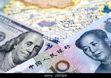 US-Dollar und chinesischer Yuan auf der Karte von China. Handelskrieg zwischen den USA und China, Wirtschaftssanktionen Stockfoto