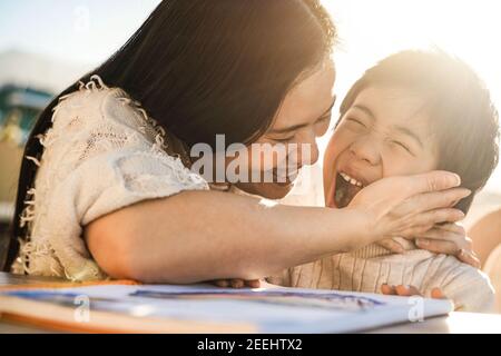 Glücklich asiatische junge Mutter mit Spaß mit ihrem Kind im Freien Im Sommer sonnigen Tag - Fokus auf Frau Gesicht Stockfoto