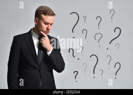 Attraktiver Mann in einem Anzug ist zu denken, wie zu lösen Die angesammelten Probleme Stockfoto