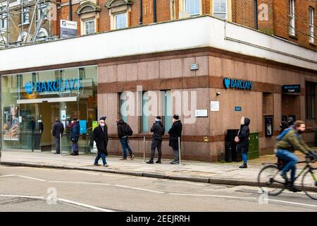 London - Menschen Schlange, während soziale Distanzierung außerhalb Barclays Bank Ealing Broadway-Niederlassung Stockfoto