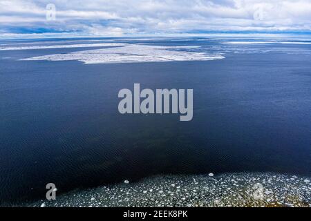 Eisblöcke, die in einem ruhigen Meerwasser herumtreiben, schaffen interessante Luftbilder. Stockfoto