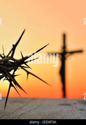 Dornenkrone von Jesus Christus gegen Silhouette der katholischen Kreuz bei Sonnenuntergang Hintergrund Stockfoto