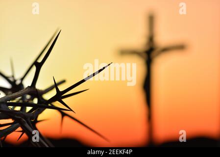 Dornenkrone von Jesus Christus gegen Silhouette der katholischen Kreuz bei Sonnenuntergang Hintergrund Stockfoto