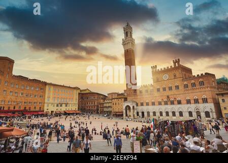 Siena, Italien - 11. September 2019: Sonnenuntergang über Touristen in Piazza del Campo in einem bewölkten Tag, Siena, Region der Toskana, Italien Stockfoto