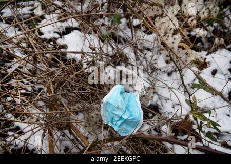 London, Hackney Marshes. Ausrangierte Gesichtsmask im Schnee Stockfoto