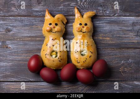 Hacksteaks mit grünen Zwiebeln und Ei, in Form von Kaninchen auf einem Holztisch. Köstliches hausgemachtes Kinderfrühstück Stockfoto