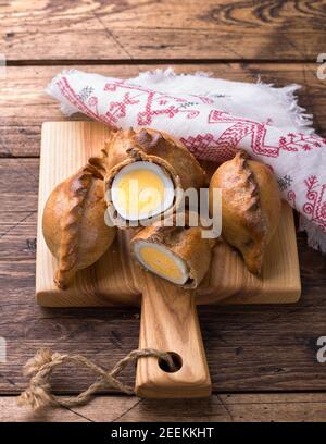 Russische traditionelle Roggenpasteten mit Ei, kokurki, auf einem Holztisch, rustikalen Stil. Köstliche hausgemachte Urlaubskost und Snack Stockfoto