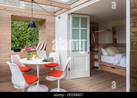 Gartenstudio mit Eero Saarinen Tulip Esstisch und Stühle, Wände, Boden und Bett in Douglas Fir von Dominic Ash Stockfoto