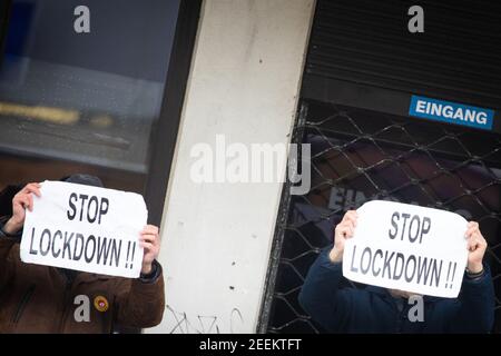 Hamburg, Deutschland. Februar 2021, 16th. Zwei Männer halten Schilder mit der Aufschrift „Stop Lockdown!!!“ Bei einer spontanen Demonstration nach einer Suche in einer Arztpraxis. Polizei und Staatsanwälte durchsuchten die Büros und Wohnungen zweier Hamburger Ärzte, die angeblich falsche Bescheinigungen für Maskenabweisen ausgestellt hatten. Einige Leute versammelten sich vor beiden Praktiken und zeigten ihre Solidarität mit den Ärzten. Quelle: Christian Charisius/dpa/Alamy Live News Stockfoto